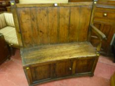 A fine 18th Century elm and pine box seat settle having a slightly curved back with an arm at one