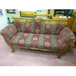 A double ended early 20th Century sofa having a shaped rail back with gently scrolled arms and