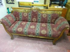 A double ended early 20th Century sofa having a shaped rail back with gently scrolled arms and