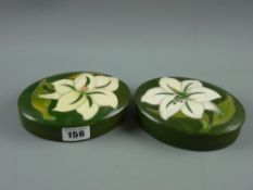 Two Moorcroft pottery 'Bermuda Lily' trinket boxes and covers, 13 cms wide, one with paper labels