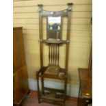 A 1930's polished hallstand having a bevelled mirror to the top with shaped spindle supports