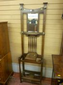 A 1930's polished hallstand having a bevelled mirror to the top with shaped spindle supports