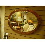 A vintage beaten copper framed oval wall mirror with bevelled edge glass, 59.5 x 86 cms