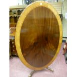 An excellent reproduction crossbanded mahogany oval topped breakfast table on turned column base
