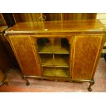 A late 19th Century mahogany and walnut three door bookcase, central glazed door flanked by