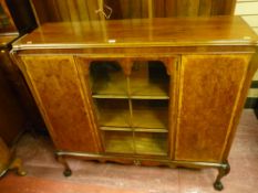 A late 19th Century mahogany and walnut three door bookcase, central glazed door flanked by