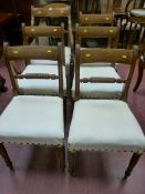 A set of six (five plus one) Regency mahogany dining chairs with broad line inlaid top rail,