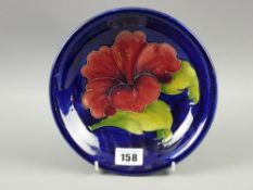 A Moorcroft pottery 'Hibiscus' plate, 18.5 cms diameter, painted and impressed factory marks to