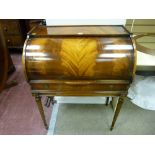 A reproduction crossbanded mahogany lady's cylinder bureau with slide-out red gilt tooled work