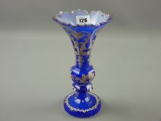 A late 19th Century Bohemian blue glass vase, facet cut bulbous column and base with white painted