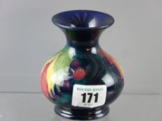 A small Moorcroft pottery 'Leaf and Berry' decorated vase, inscribed 'W Moorcroft' and impressed