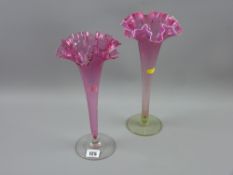 A cranberry and vaseline glass single flute vase with circular footed base and frilly edged top,