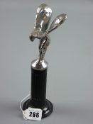 A 'Spirit of Ecstasy' cast metal and silvered figure car mascot, mounted on a segmented metal column