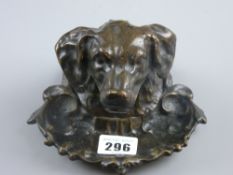 A cast bronze patinated inkstand in the form of a dog's head, the top part lifting to reveal an