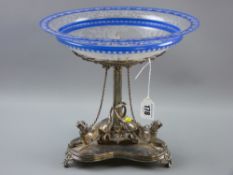 An electroplate table centrepiece on tri-form base, each edge with a figure of a tethered hound,