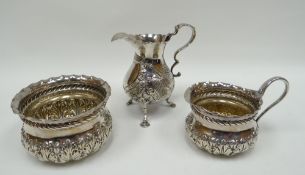 A silver cream jug and matching sugar basin having continuous raised acanthus decoration to the body