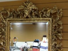 An impressive reproduction Rococo-leaf style gilt-framed bevelled wall-mirror, glass plate size 74 x