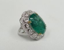 A Colombian emerald and diamond ring of lobed oval form, the raised emerald in a four-claw setting