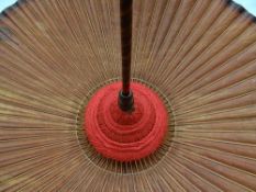 An early-twentieth century Oriental parasol with burnt-bamboo shaft and wooden handle and with