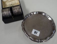 A small silver salver (damage), 4.3ozs; together with a cased pair of silver napkin-rings; a three