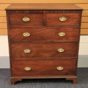 A mahogany chest of three graduated drawers and two short, brass furnished and on bracket feet,