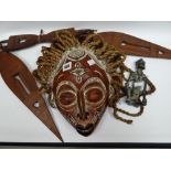 A painted native carved mask with wicker-work 'hair'; together with a carved three-piece spear and a