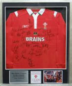 A framed Welsh Rugby Union home jersey by Reebok, signed by thirty-four of the ground-breaking