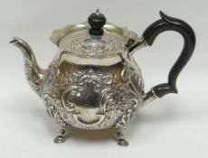 An embossed silver teapot with composite handle and knop and raised on pad-feet, London 1901, 12ozs