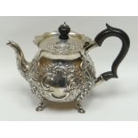 An embossed silver teapot with composite handle and knop and raised on pad-feet, London 1901, 12ozs