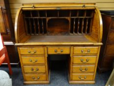 A good vintage oak roll-top desk with a pair of pedestals of four drawers to flank a single centre