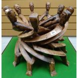 A one-piece carved African tribal 'unity-table' of nine heads, 46cms