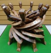 A one-piece carved African tribal 'unity-table' of nine heads, 46cms