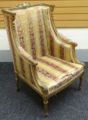 A French-empire style carved gilt-wood armchair, with ornate floral rail, striped upholstery,