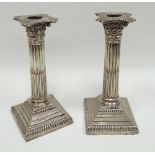 A pair of silver square based Corinthian-column candle-holders, London 1896 (weighted)