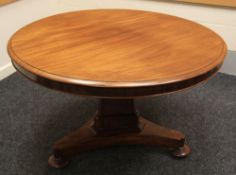 A circular mahogany breakfast table on a tri-footed shaped platform base, 119cms diam