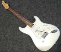 A silver and white Aria electric guitar