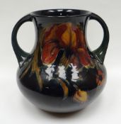 A Moorcroft green and blue ground twin handled vase in the 'Spanish Iris' pattern, signed William