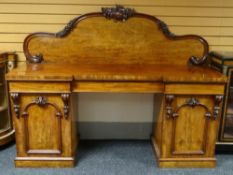 A break-front mahogany twin-pedestal sideboard, three drawers above two cupboards and with carve