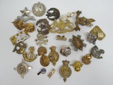 A quantity of assorted regimental cap badges, shoulder titles and collar badges