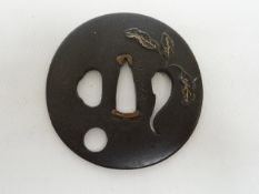 A signed Japanese sword tsuba with gilt leaf decoration