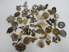 A quantity of assorted regimental cap badges, shoulder titles and collar badges