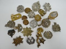 A quantity of assorted regimental cap badges, shoulder titles and collar badges