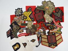 A quantity of regimental cloth patches and insignia