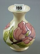 A Moorcroft Magnolia cream ground vase, impressed and painted marks to the base, 13 cms high