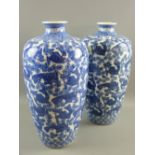 A large pair of Oriental export blue and white vases decorated with constant bands of carp and