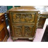 A carved Oriental hardwood cocktail cabinet with lift-up lid and drop down front, twin base cupboard