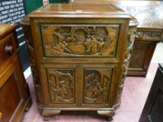 A carved Oriental hardwood cocktail cabinet with lift-up lid and drop down front, twin base cupboard