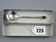 A beaten silver decorative spoon with circular bowl and shaped handle with floral decoration and