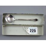 A beaten silver decorative spoon with circular bowl and shaped handle with floral decoration and