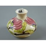 A Moorcroft Magnolia squat baluster base on a cream ground, impressed and painted marks to the base,